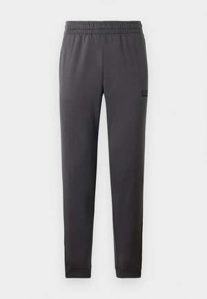 Gray athletic pants in a smooth fabric, featuring an elastic waistband and tapered legs. Minimal branding on the side.