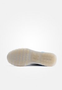 Suola della scarpa realizzata in un materiale gommoso traslucido di un beige chiaro, con un motivo di grip testurizzato e accenti blu lungo i bordi.
