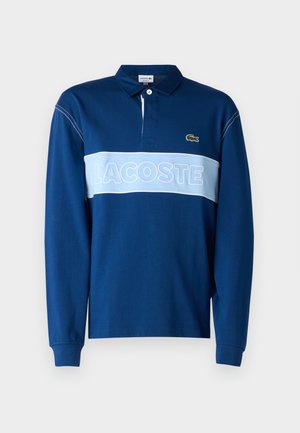 Mørkeblå langermet polo skjorte med lyseblå horisontal stripe som har "LACOSTE" tekst, myk stoffkvalitet og krage med tre knapper.