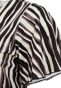 Kratām piedurknēm augšdaļa ar zebras rakstu melnā, bežā un brūnā krāsā. Izgatavota no mīksta auduma ar plūstošu, teksturētu apdari.