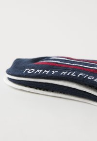 Tommy Hilfiger strumpor i marinblått och vitt. Har horisontella ränder och textdetalj, tillverkade av ett strukturerat stickat material.