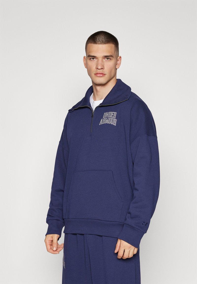 Sudadera de color azul marino con cremallera, hecha de una mezcla de algodón, con un alto cuello, que cuenta con un bolsillo frontal y un logo bordado.