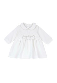 Vestido de algodón blanco con mangas largas, cuello redondo, cuerpo acolchado y detalles de estrellas bordadas en la cintura. Textura suave, forma de línea A.