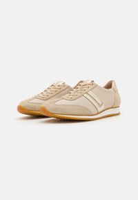 Beige Leder-Sneaker mit Wildlederakzenten, Schnürdesign und Gummisohle. Mit metallic Streifen und kontrastierenden Texturen.