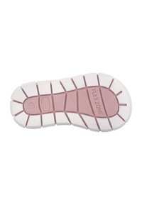 Semelle de chaussure avec un intermédiaire en caoutchouc rose flexible présentant des rainures distinctes et une semelle extérieure blanche texturée portant l'étiquette "FLEXZONE."