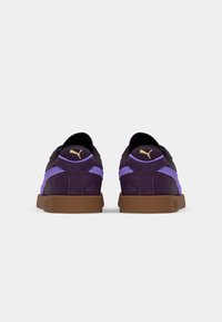 Fioletowe zamszowe sneakersy z czarnymi akcentami, z fioletową siateczką i brązową gumową podeszwą. Złoty detal z logo na pięcie.