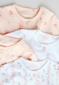 Bløde pastel babybodystockings med blomster- og sommerfugleprint, rund hals og en enkelt sommerfugleknap ved kraven, lagt fladt.