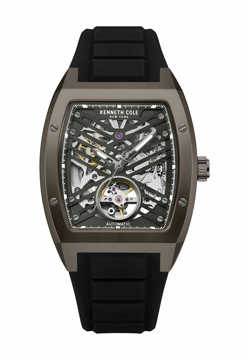 Automatische Armbanduhr mit einem schwarzen Gummiarmband, dunkelmetallischem Gehäuse, Skelettzifferblatt, das Zahnräder zeigt, silbernen Akzenten und lila Details.