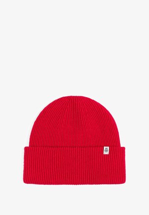 Red knitted beanie with a ribbed texture, featuring a folded cuff and a small white logo tag on the side.