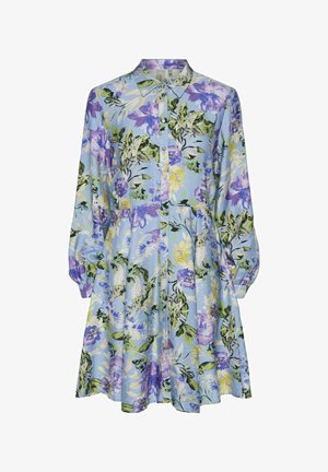 Kevään kukkakuosiset mekko vaaleansinisessä kankaassa, jossa on purppura-, vihreä- ja keltakuosisia yksityiskohtia. Mekossa on napitus edessä ja rypytetty vyötärö pitkillä hihoilla.