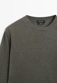 Olivengrøn hør-sweater med rund hals og ribstrikket krave, mærket "Massimo Dutti," vist mod en hvid baggrund.