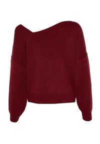 Pull asymétrique rouge foncé avec une manche longue et une épaule dénudée, des poignets et un ourlet côtelés.