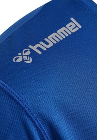Blauwe sportstof met een gestructureerd oppervlak, voorzien van een zilveren "hummel"-logo en naadloze stiksels.