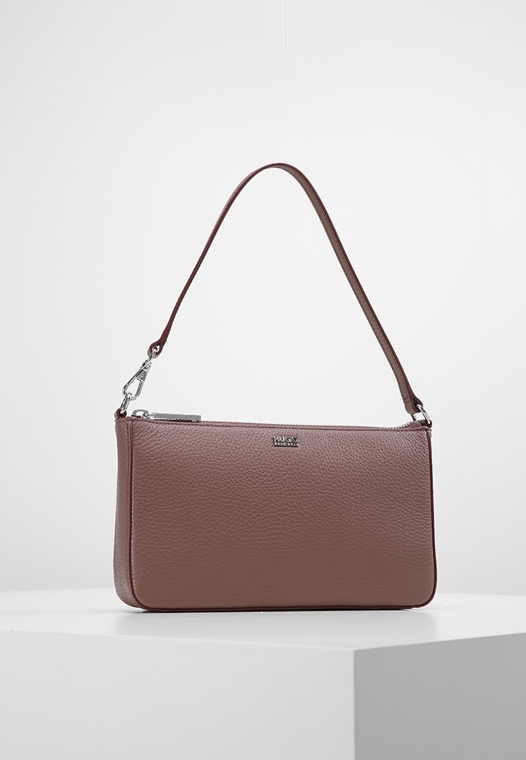 Petit sac à main rectangulaire en cuir marron avec une fine bandoulière et une fermeture éclair sur le dessus.