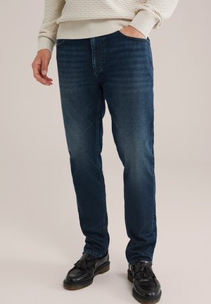 Donkerblauwe denim jeans met een slim fit, voorzien van vijf zakken en subtiele slijtage. Gladde textuur, stof van gemiddelde gewicht.