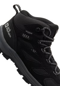 Scarpa da trekking nera con una combinazione di materiali lisci e testurizzati, punta rinforzata e suola in gomma resistente con design per la trazione.