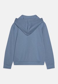 Sweatshirt azul com um tecido macio e texturizado. Apresenta um capuz espaçoso, mangas longas e punhos e bainha canelados. Design minimalista.