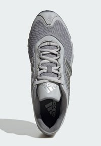 Grauer Sportschuh mit einer Mesh-Oberfläche, Gummisohle und einem Design mit drei Streifen. Enthält graue Schnürsenkel und ein Markenlabel an der Zunge.