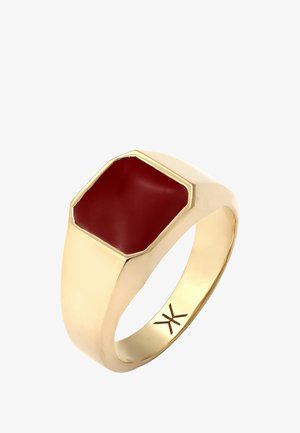 Guld ring med en hexagonal rød sten i midten. Glat tekstur, poleret overflade og en bred skæfte. Brandlogoet er synligt indeni skæftet.