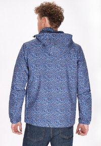 Giacca con cappuccio blu caratterizzata da un motivo geometrico nei colori rosa, bianco e azzurro su un tessuto testurizzato. Maniche lunghe e vestibilità rilassata.
