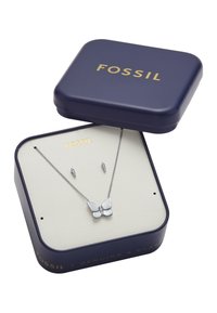 Vlinder-vormige zilveren ketting en bijpassende oorbellen gepresenteerd in een marineblauwe Fossil sieradenbox met gouden letters.