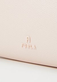 Borsa in pelle texturizzata rosa chiaro con logo "A FURLA" in rilievo; finitura liscia con un sottile motivo e un aspetto morbido.