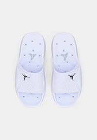 Λευκά πέδιλα με υφαντό επάνω μέρος, ανοιχτή μύτη και σόλα με κυκλικά σχέδια. Διαθέτει μαύρη λεπτομέρεια με λογότυπο στο πλάι.