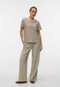 Randig kortärmad skjorta i kräm och bruna färger, matchad med ljusbeige vida byxor och bruna ballerina. Mjuk tygstruktur.