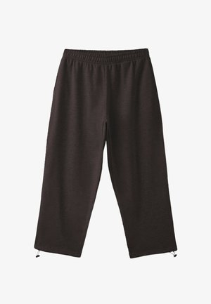 Personne portant un pantalon de jogging marron foncé avec une bande latérale blanche et un sweat à capuche assorti, levant la capuche pour révéler un sous-vêtement blanc.