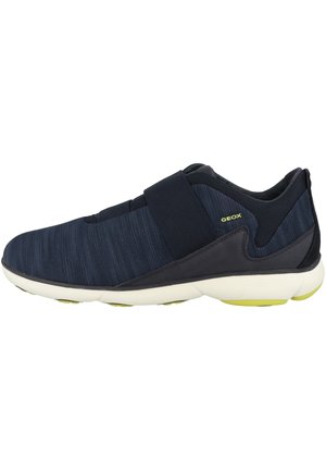 Zapatilla navy con parte superior de textil y cinta de velcro, suave acolchado y suela blanca duradera con acentos verdes.