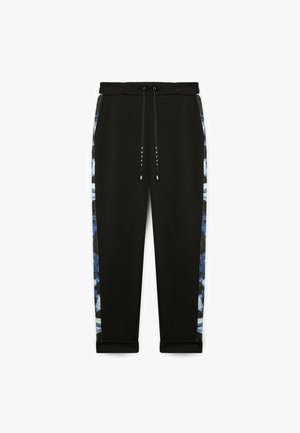 Zwarte tapered joggers met een trekkoord in de taille, voorzien van blauw en witte patronen langs de zijkanten en omgeslagen mouwuiteinden.