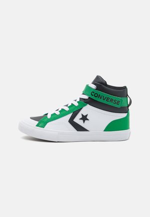 Zapatillas altas con un diseño en negro, blanco y verde, con materiales texturizados, una correa de velcro y suela de goma.