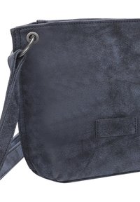 Borsa a tracolla in finta pelle blu scuro con una texture liscia, accessori in metallo e una patch con logo ricamato. Forma rettangolare compatta.