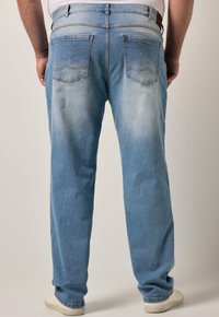 Světle modré džíny z denimu s vybledlým potiskem, s rovný střih, pět Pocket designem a viditelnými švy.