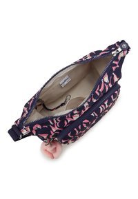 Small navy and pink patterned crossbody bag with open zipper, beige interior, key clip, and attached pink fuzzy pom-pom charm.