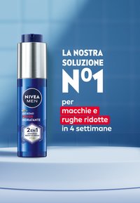 Bottiglia cilindrica blu con un tappo argentato, etichettata "NIVEA MEN," con testo bianco e rosso. Contenitore progettato per l'anti-invecchiamento e l'idratazione.
