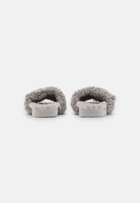 Fuzzy gray slippers with a soft, textured upper and flat sole, featuring a simple design and rounded shape. No prominent hardware or patterns.