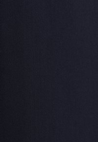 Ciemnogranatowa tkanina o delikatnej diagonalnej fakturze skośnego splotu, pokazująca szczegółowe zbliżenie powierzchni materiału.