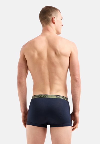 Boxer ajustados para hombre en color azul marino con una cinturilla elástica verde claro que presenta el logo "Emporio Armani", textura suave y diseño ceñido.