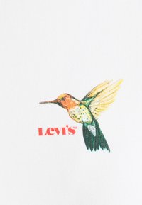Tela blanca con un gráfico colorido de un colibrí que presenta detalles en verde, amarillo y naranja, junto con el logo rojo de "Levi's" debajo.