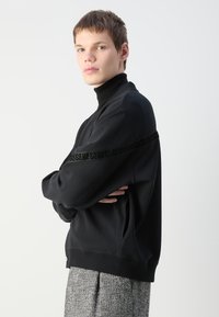 HUGO DEQUILOS - Zip-up sweatshirt - black