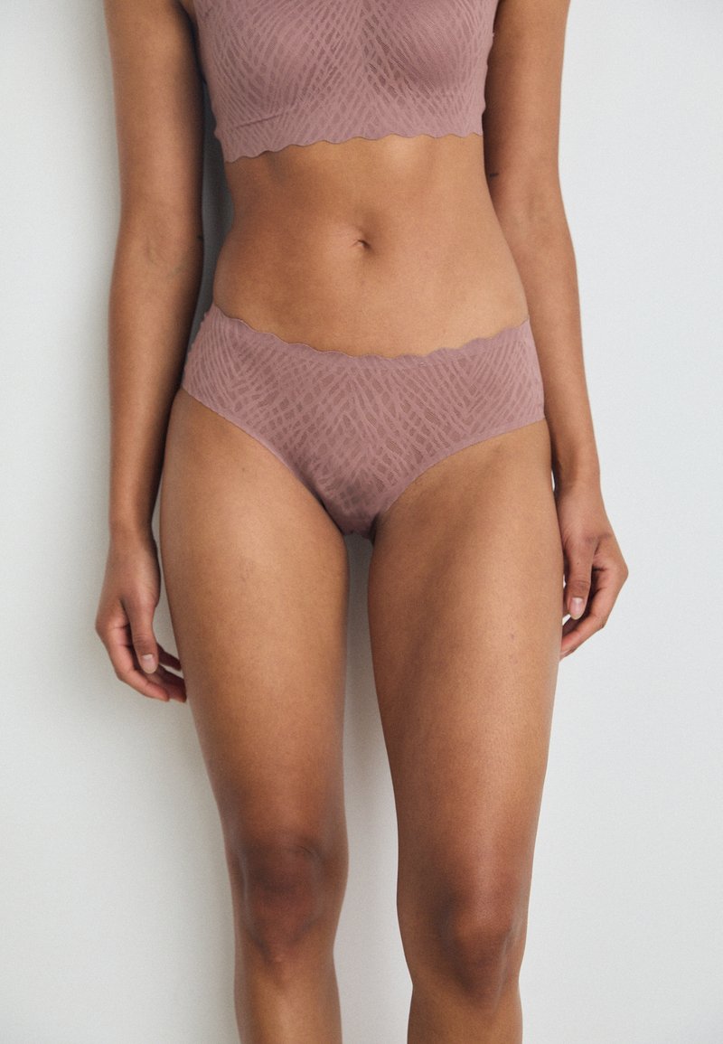 Mauve undertøysett med en bralette og matchende høyhåndte truser. Stoffet har et subtilt teksturert mønster med bølgete kanter.