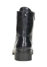 Zwarte leren enkelboot met zijrits, lus en een gestructureerde afwerking gezien vanuit de achterkant met een dikke rubberen zool.