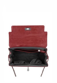 Sac à main en daim bordeaux avec une fermeture magnétique, doté d'un intérieur doublé noir, une poche zippée et deux compartiments ouverts.