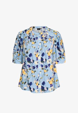 Vaaleansininen paita, jossa keltainen ja violetti kukkakuvio, lyhyet liehukevät hihat, pyöreä pääntie, nappikiinnitys edessä ja laskostetut yksityiskohdat rinnassa.