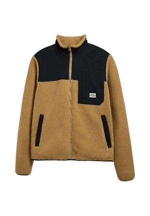 Veste en polaire sherpa beige et noire avec fermeture éclair intégrale à l'avant, poche poitrine noire et deux poches latérales bordées de noir.
