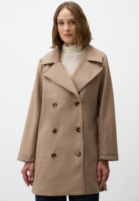 Cappotto marrone doppiopetto con colletto a scollo a V, realizzato in tessuto testurizzato. Presenta grandi bottoni scuri e maniche larghe e dritte.