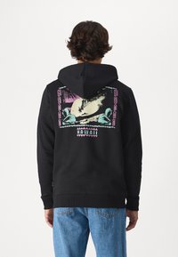 Black hoodie with a colorful graphic depicting Hawaii, featuring palm trees and waves. Includes a front kangaroo pocket and ribbed cuffs.
