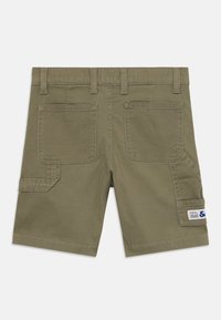 Olivgröna bomullsshorts med midjeband, två bakfickor och en sidofick med knapp som har en etikett. Slät textur och avslappnad design.