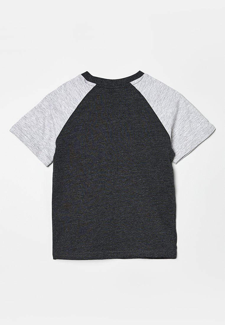 T-shirt à manches courtes en raglan avec un corps gris foncé et des manches gris clair posé à plat sur une surface blanche.